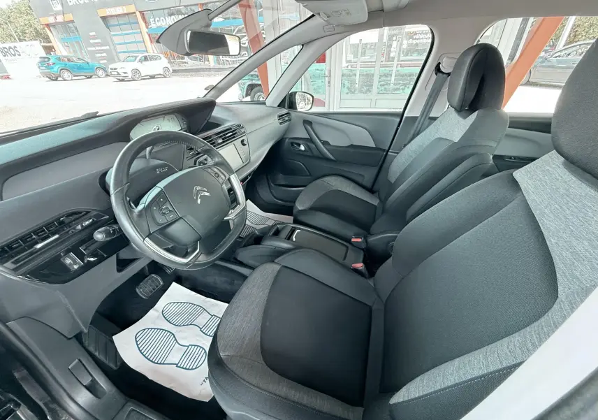 Vue intérieure côté conducteur de la Citroën C4 Spacetourer 2019, sièges tissu gris et noir, tableau de bord moderne.