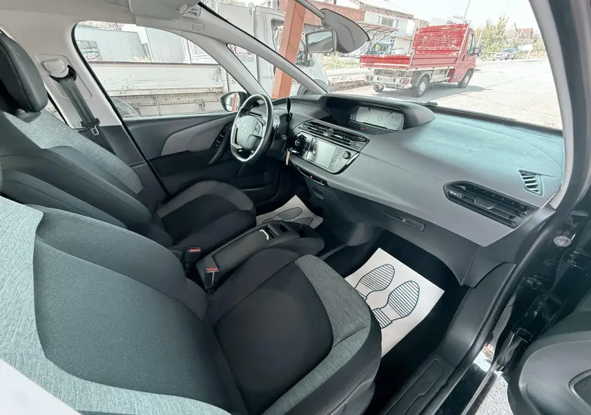 Intérieur avant du Citroën C4 Spacetourer noir, vue côté droit montrant sièges gris et tableau de bord moderne.