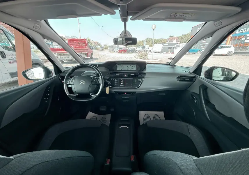 Vue intérieure avant du Citroën C4 Spacetourer noir, montrant le tableau de bord et le volant multifonction.