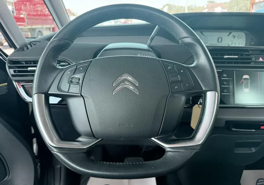 Vue rapprochée du volant noir de la Citroën C4 Spacetourer 2019 avec commandes intégrées et tableau de bord visible.