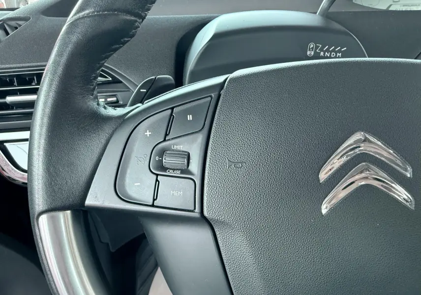 Gros plan sur le volant noir de la Citroën C4 Spacetourer 2019, avec commandes intégrées et logo chromé visible.