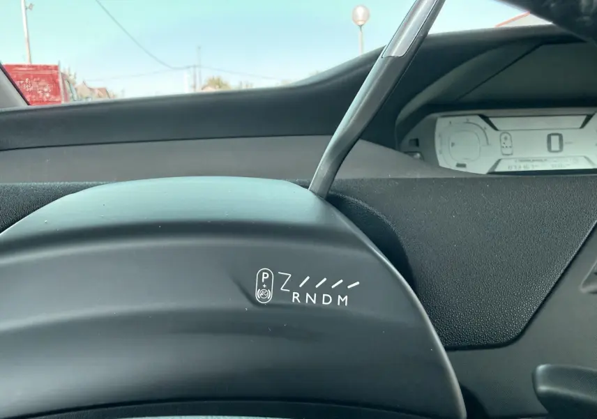 Gros plan intérieur sur le levier de vitesses automatique et le tableau de bord numérique d'une Citroën C4 Spacetourer noire.
