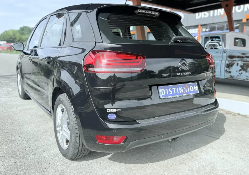 Vue 3/4 arrière droite d'une Citroën C4 Spacetourer noire, avec feux arrière rouges et plaque Distinxion.