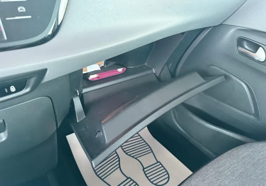 Vue intérieure côté passager du coffre à gants ouvert du Citroën C4 Spacetourer noir, montrant le rangement et la porte du véhicule.
