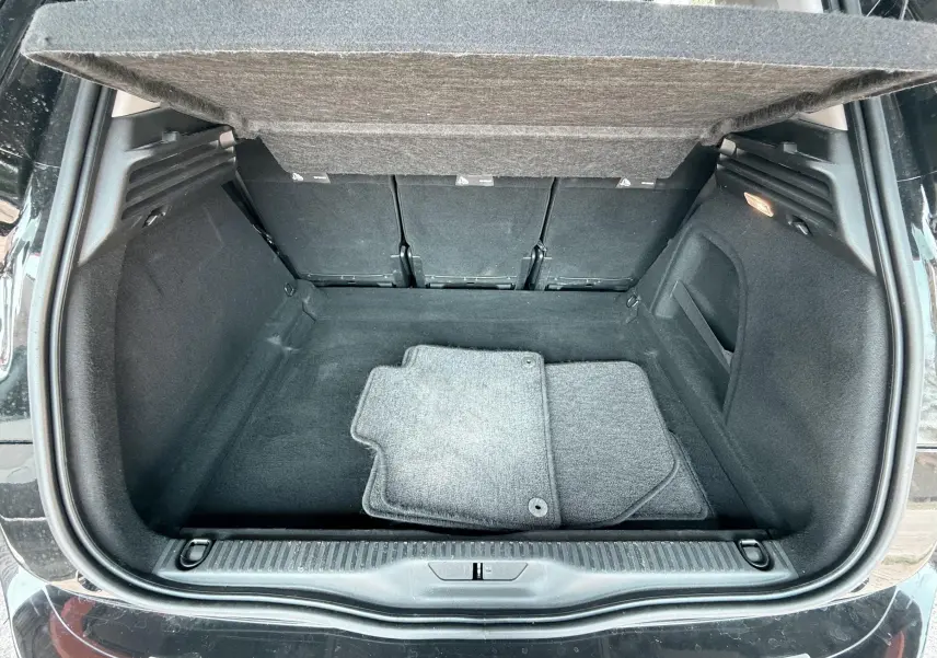 Coffre ouvert vu de l'arrière d'une Citroën C4 Spacetourer noire avec tapis de sol gris à l'intérieur.