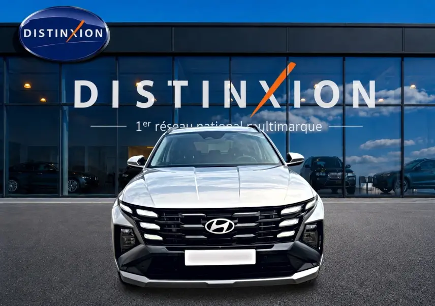 Vue frontale du Hyundai Tucson gris shimmering 2026 avec calandre noire distinctive et feux LED intégrés.