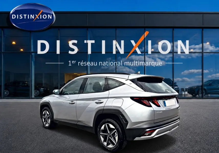 Vue 3/4 arrière droite du Hyundai Tucson gris shimmering 2026 devant un showroom Distinxion.