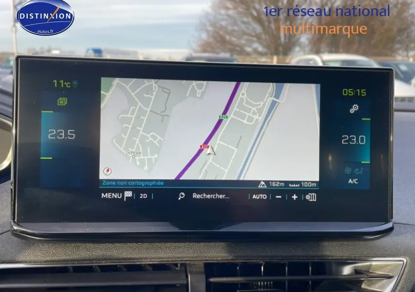 Écran tactile central du tableau de bord du Peugeot 3008 bleu, affichant la navigation GPS en extérieur.