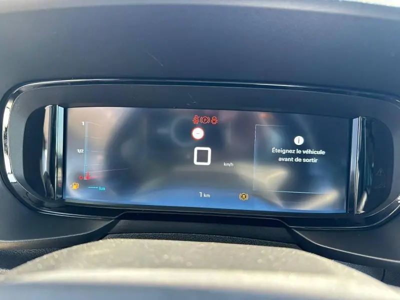 Vue rapprochée de l'écran multifonction numérique du tableau de bord du Citroën Berlingo 2025 avec affichage d'alerte.