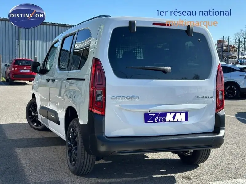 Vue 3/4 arrière droite d'un Citroën Berlingo blanc Kaolin avec vitres teintées et jantes noires.