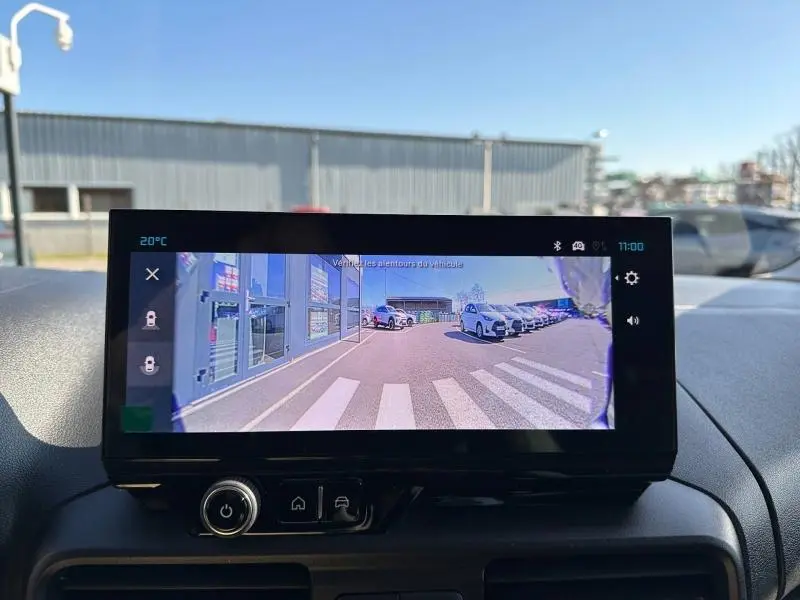 Écran tactile intérieur du Citroën Berlingo 2025 affichant la vue caméra arrière sur un parking ensoleillé.