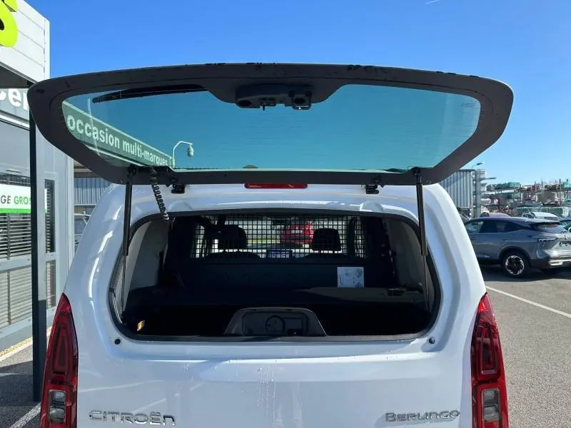 Vue arrière du Citroën Berlingo blanc 2025 avec hayon ouvert, montrant l’intérieur et la grille de séparation.
