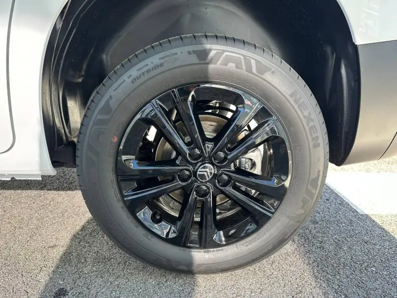 Gros plan sur la roue avant droite du Citroën Berlingo 2025 blanche avec jante noire brillante et pneu Nexen.