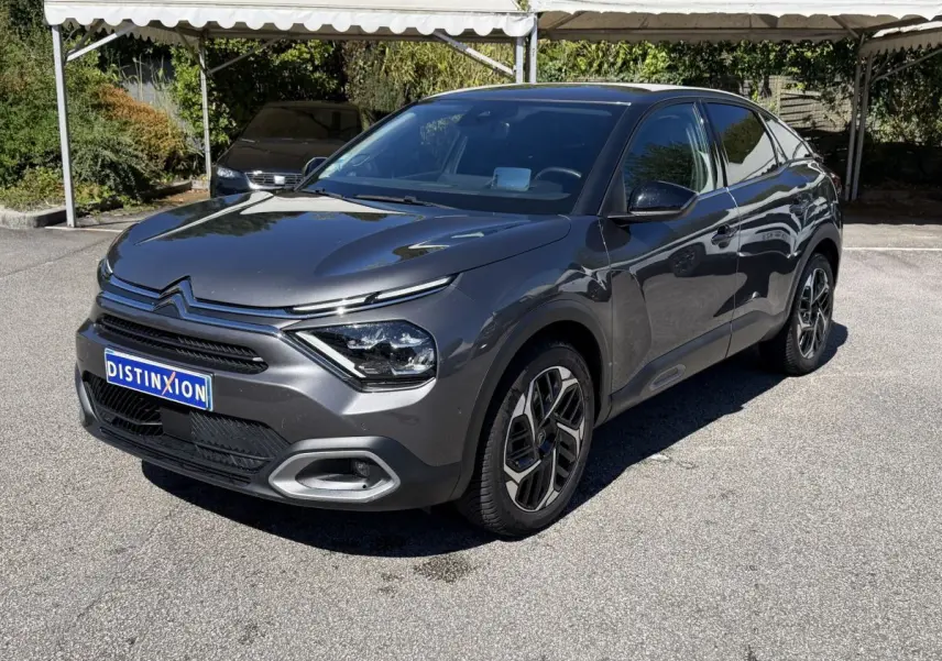 Citroën C4 PureTech 130 S&S Shine gris foncé vue 3/4 avant droit sur parking ensoleillé.