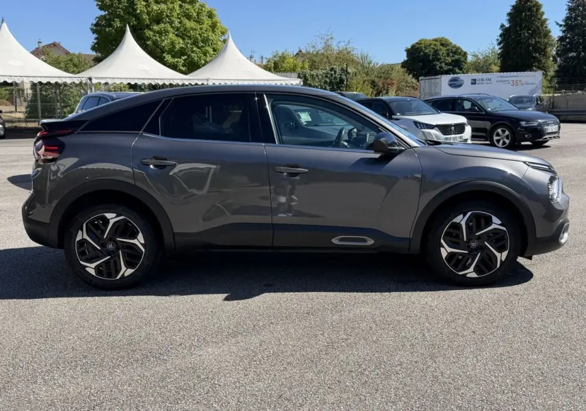 Profil droit d'une Citroën C4 PureTech 130 S&S Shine gris foncé, avec jantes alliage et lignes fluides modernes.