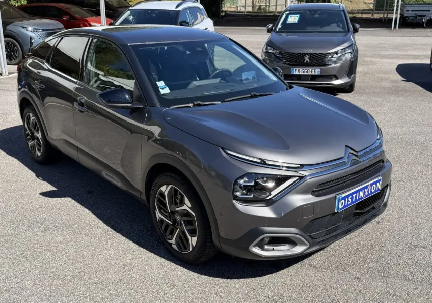 Citroën C4 PureTech 130 S&S Shine gris foncé vue 3/4 avant avec signature lumineuse distinctive et jantes stylées.