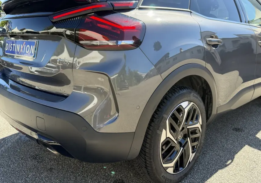 Vue 3/4 arrière droite d'une Citroën C4 gris foncé avec feux arrière LED et jante alliage au design moderne.