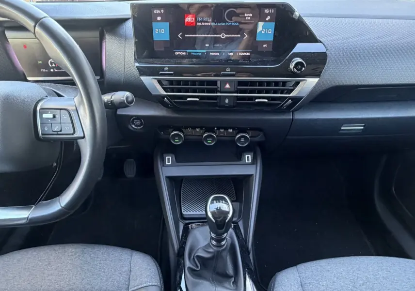 Vue intérieure centrée sur la console et le volant cuir noir de la Citroën C4 PureTech 130 S&S Shine 2022.