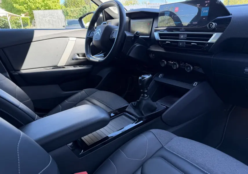 Intérieur avant droit de la Citroën C4 PureTech 130 S&S Shine 2022, avec tableau de bord numérique et volant cuir noir.