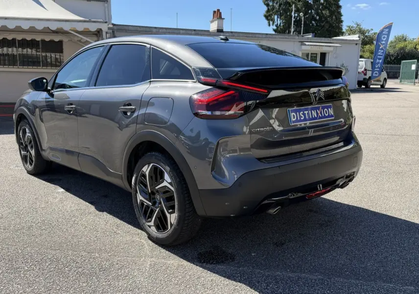 Vue 3/4 arrière droite d'une Citroën C4 PureTech 130 gris foncé avec feux arrière LED et jantes alliage noires.