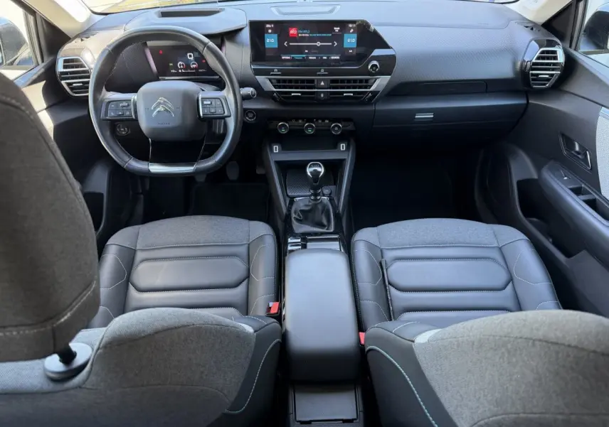Vue intérieure avant de la Citroën C4 PureTech 130 S&S Shine 2022, tableau de bord moderne avec écran tactile et volant cuir.