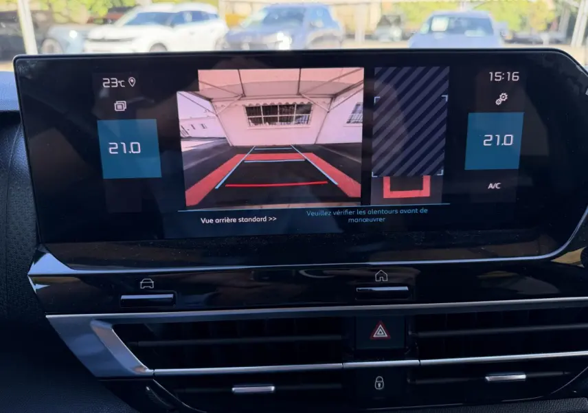 Écran tactile central de la Citroën C4 gris foncé montrant la caméra de recul et la climatisation à 21°C.