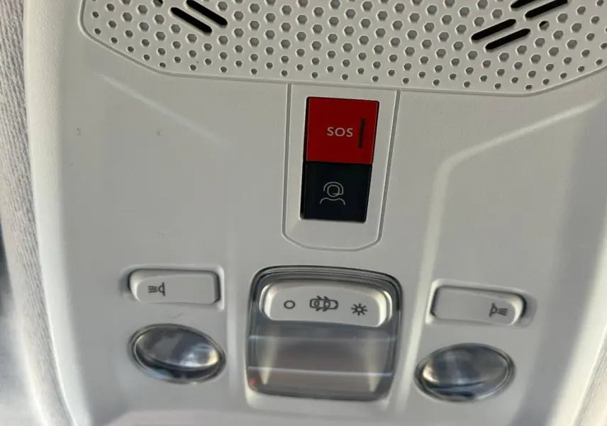 Gros plan sur la console de plafonnier intérieur gris clair avec bouton SOS et commandes d’éclairage de la Peugeot 208 2025.
