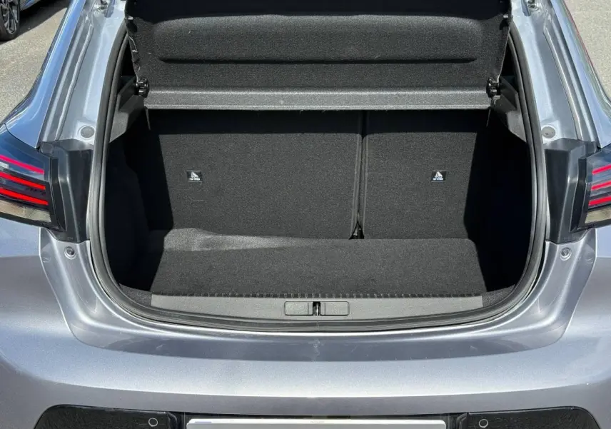 Coffre ouvert vu de l'arrière d'une Peugeot 208 gris Artense avec feux arrière LED visibles.
