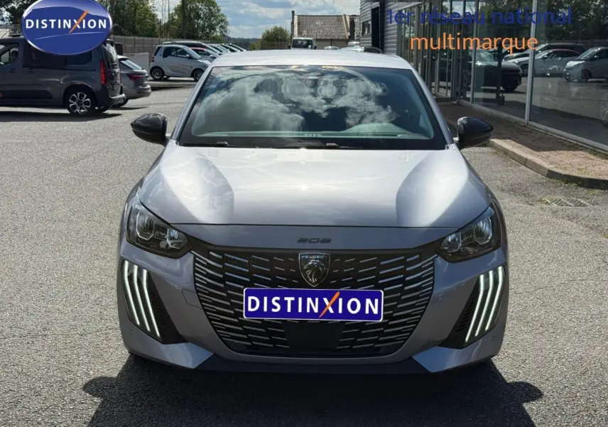 Vue avant d'une Peugeot 208 gris Artense avec feux diurnes LED en forme de griffes et calandre noire distinctive.