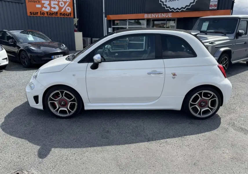 Profil côté gauche d'une ABARTH 500 blanche avec jantes sport 17 pouces et logo Abarth visible sur la porte.