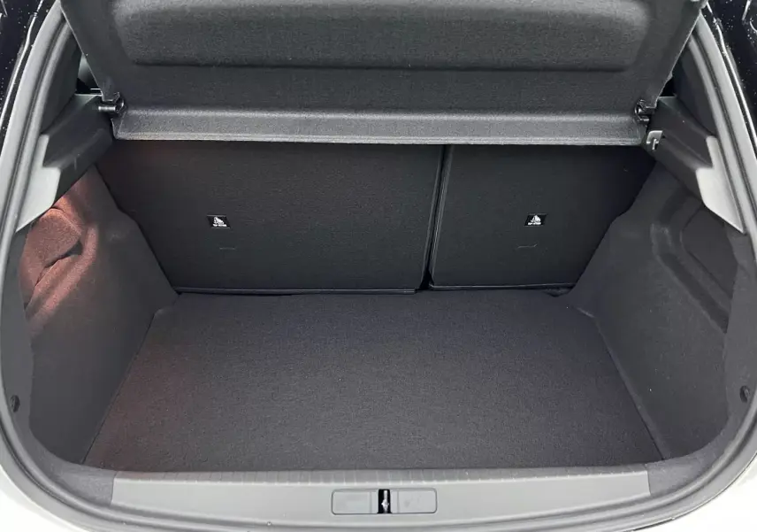 Coffre ouvert de la Peugeot 208 blanche 1.2 Hybrid 136 GT, vue plongeante sur l’espace de chargement vide.