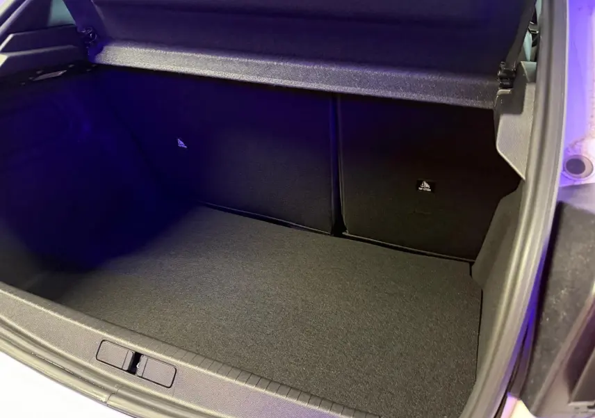 Coffre ouvert de la Peugeot 208 1.2 Hybrid 136 GT blanc, montrant un espace de rangement propre et vide.