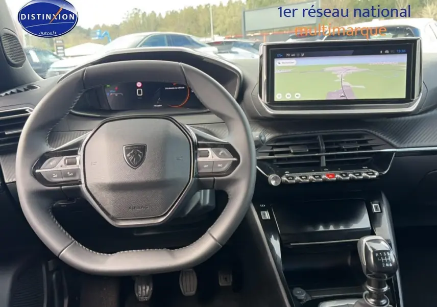 Vue intérieure du poste de conduite du Peugeot 2008 noir 2025, avec volant multifonction et écran tactile central.