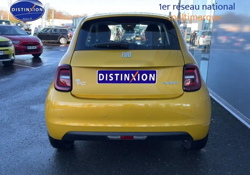 Vue arrière d'une FIAT 500 hybride 2026 en Yellow Gold Métal, avec feux arrière LED et logo distinctif Torino pied de poule.