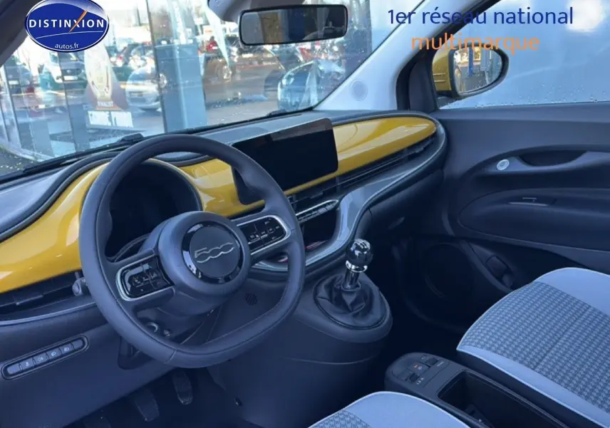 Vue intérieure côté conducteur de la FIAT 500 hybrid 2026 avec tableau de bord Yellow Gold Métal et motif pied de poule.