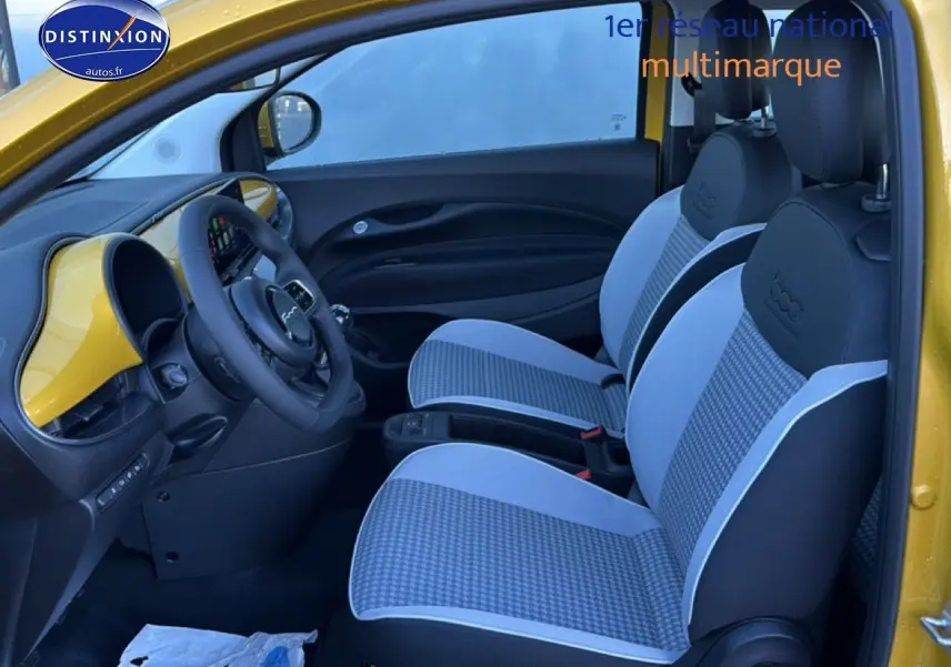 Vue intérieure côté conducteur de la Fiat 500 Yellow Gold Métal avec sièges à motif pied-de-poule et tableau de bord assorti.