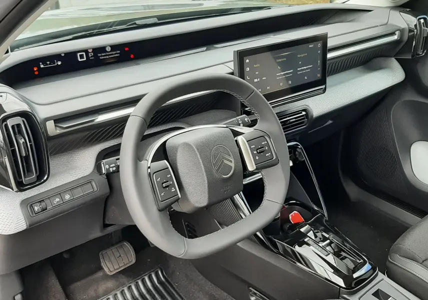 Vue intérieure côté conducteur du Citroën C3 Aircross 2026, tableau de bord moderne avec écran tactile central et volant compact.