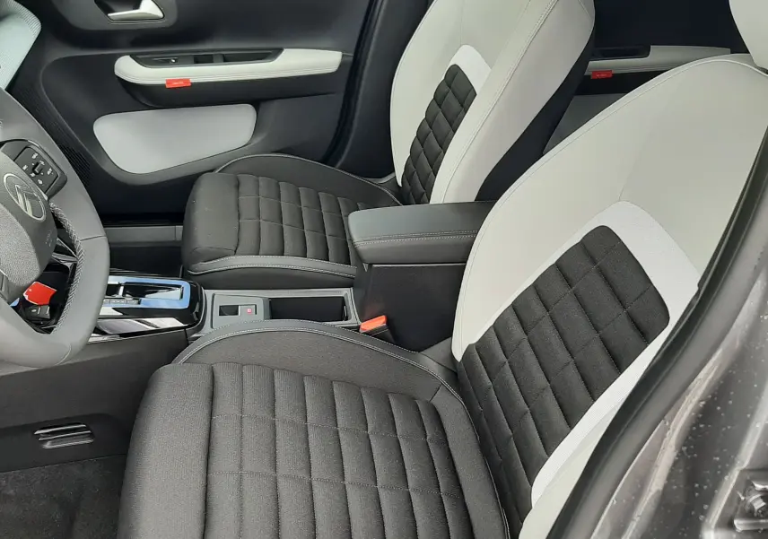 Vue intérieure côté conducteur de la Citroën C3 Aircross 2026, sièges bi-matière noir et blanc avec console centrale.