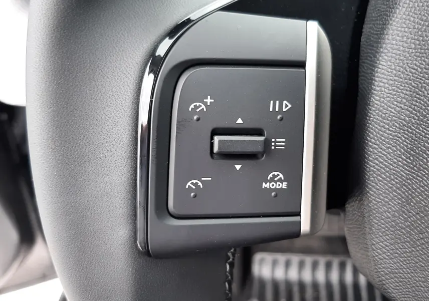 Gros plan sur les commandes multifonctions du volant du Citroën C3 Aircross gris Mercury, version hybride 2026.