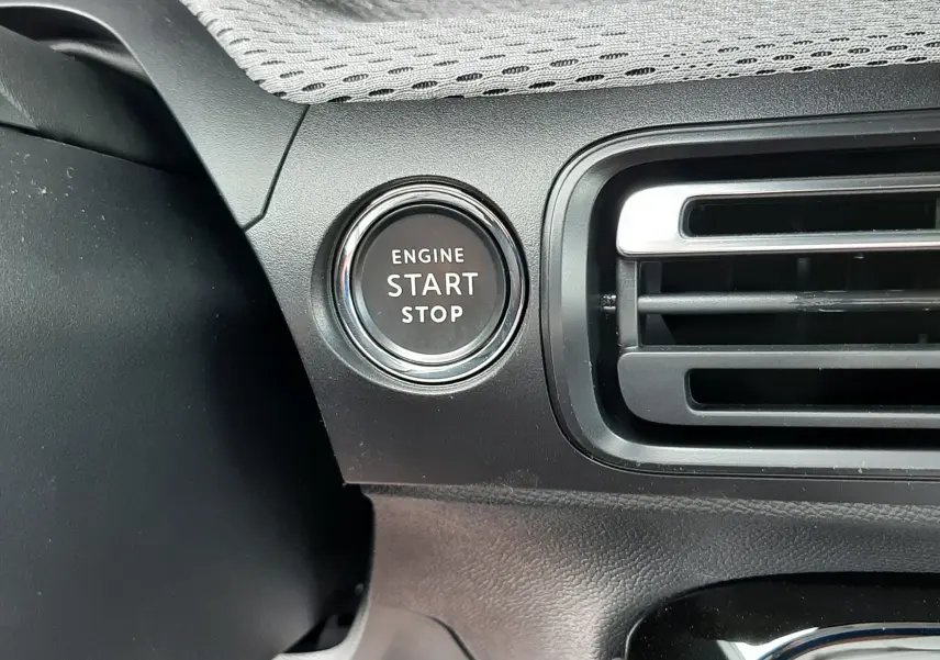 Gros plan sur le bouton start/stop moteur à gauche de la grille d’aération dans l’habitacle noir du Citroën C3 Aircross 2026.