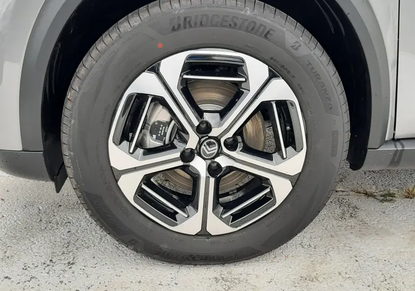 Gros plan sur la roue avant droite du Citroën C3 Aircross gris Mercury, jante alliage bicolore et pneu Bridgestone.