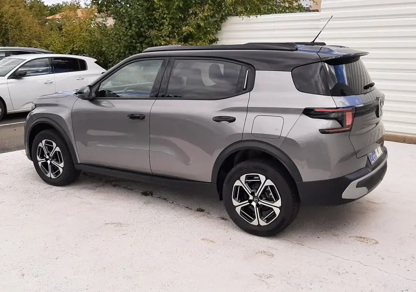 Citroën C3 Aircross 2026 gris Mercury avec toit noir, vue 3/4 arrière côté droit, jantes bi-ton et feux LED distinctifs.
