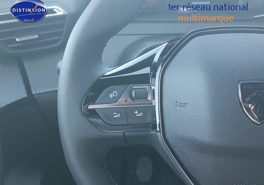 Gros plan sur le volant multifonction noir du Peugeot 2008 gris Artense, avec commandes audio intégrées.