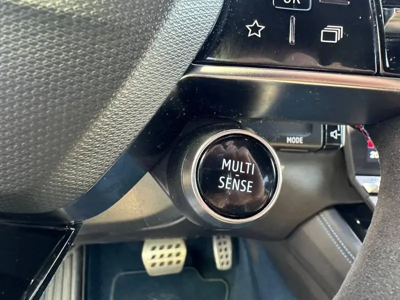 Bouton Multi Sense noir sur tableau de bord côté gauche avec pédalier sport visible, intérieur Renault Rafale bleu Sommet.