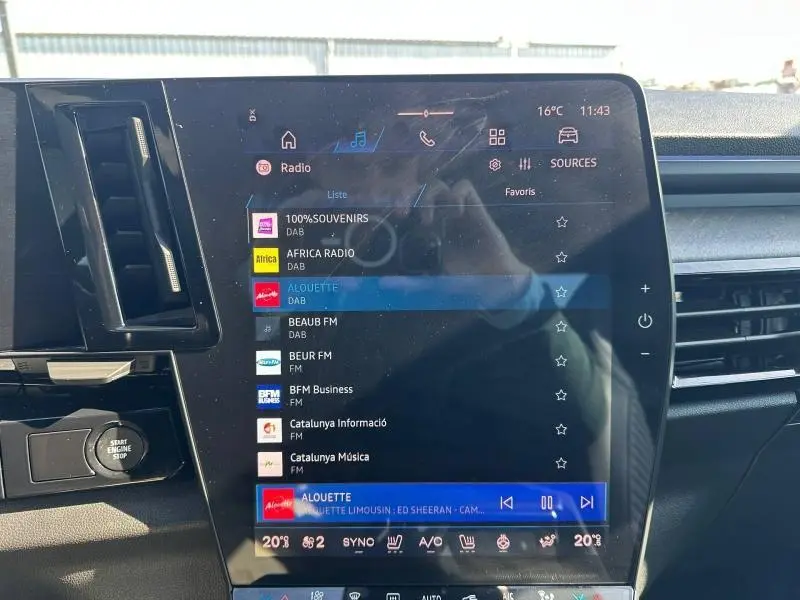 Écran tactile central affichant la radio dans l’habitacle du Renault Rafale 1.2 E-Tech bleu, vue de face.
