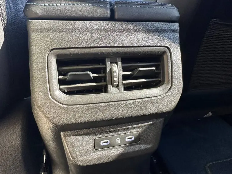 Détail des aérateurs arrière noirs et ports USB-C dans l'habitacle du Renault Rafale 2025 bleu Sommet métallisé.