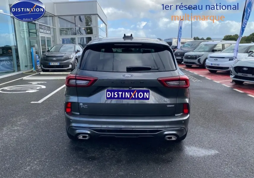 Vue arrière d'un Ford Kuga gris Magnetic Fashion Métallisée avec double sortie d'échappement et lunette arrière surteintée.