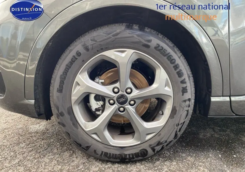 Gros plan sur la roue avant droite en jante alu du Ford Kuga gris Magnetic Fashion Métallisée 2025.