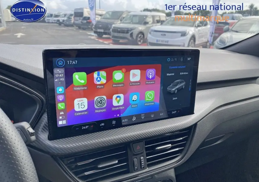 Vue intérieure du tableau de bord du Ford Kuga 2025 avec écran tactile central affichant applications connectées.