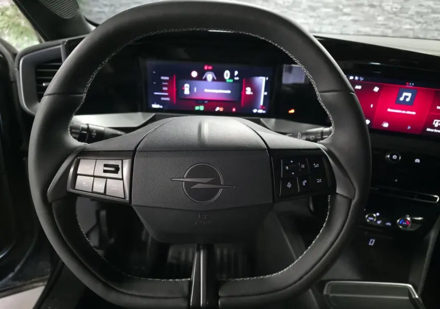 Vue centrée sur le volant noir de l'Opel Mokka-e 2025 avec tableau de bord digital et écran tactile.